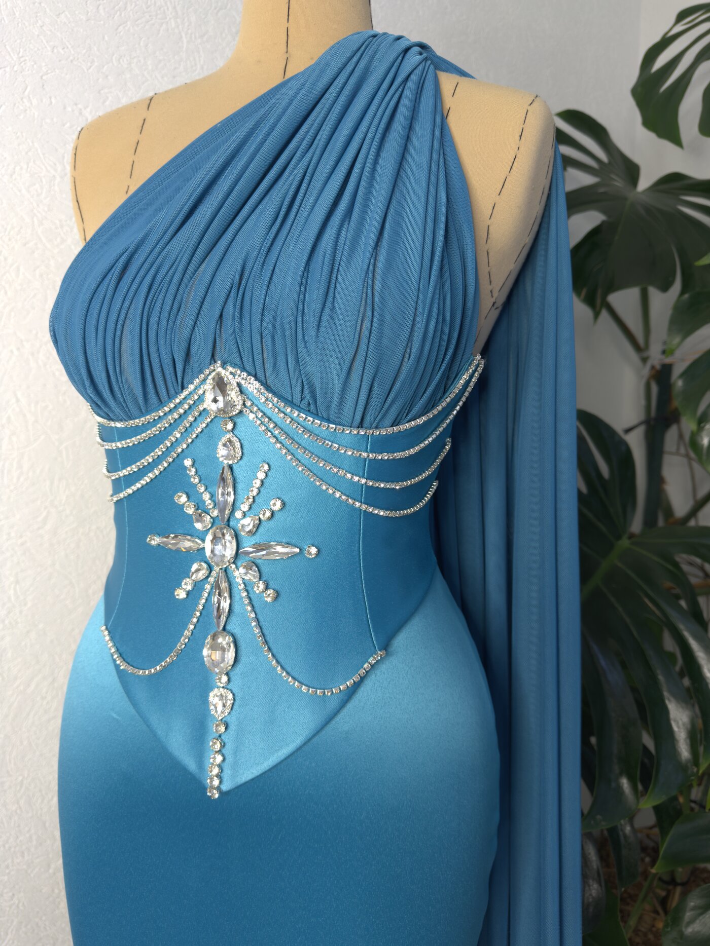 Close view of the rhinestone chain detail on the blue gown